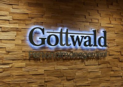 Rückleuchtende LED Leuchtbuchstaben vor Holzwand